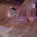 Cartoon Scene of Stone Room with Archway Old Cannon Cart Wooden Ladder and Barrel