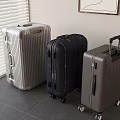 Silver Dark Blue Gray Suitcases In Indoor Setting With Window Blinds And Gray Tile Floor