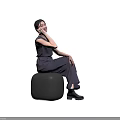 Woman Sitting On Purple Stool In Gray Jumpsuit With Ponytail And Hand On Cheek