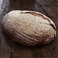 Freshly Baked Crusty Brown Bread With Sesame Seeds On Rustic Wooden Table