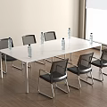 Long White Conference Table With Black Chairs And Water Bottles In Modern Office