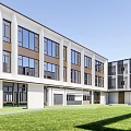 Modern Multi Story School Building With Glass Windows White Facade And Green Landscaping