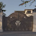 Ornate Iron Gate With Intricate Carvings Stone Pillars And Lamp Posts Front Residential House Trees