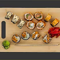 Colorful Assorted Sushi Rolls Served on Wooden Tray with Chopsticks and Garnishes