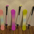 Pink Purple Yellow Snowboards And Ski Poles Leaning Against Wall On Wooden Floor
