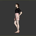 A woman wearing black top and pink skirt against gray background in standing pose