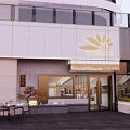 Modern Storefront Design With White Facade Gold Lotus Logo Glass Door Entrance And Outdoor Seating