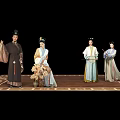 Traditional Chinese Performers In Historical Costumes With Props On Ornate Stage