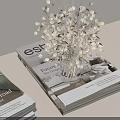 Stylish Arrangement of Stacked Books Dried Flowers in Glass Vase and Papers on Tabletop