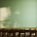 School Classroom Interior With Rows of Wooden Chairs Green Blackboard and Wooden Decorated Walls