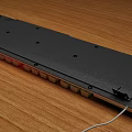 Modern Full Size White Computer Keyboard With RGB Backlit On Wooden Desk