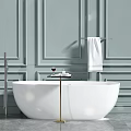 White Freestanding Bathtub Against Light Blue Paneled Walls With Gold Side Table And White Towel