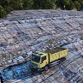 Scenic Landscape Featuring Yellow Dump Truck On Rocky Textured Ground With Puddles And Trees