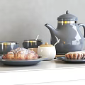 Gray Ceramic Teapot And Gold Rimmed Coffee Cups With Plates Croissants And Pastries