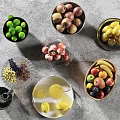 Colorful Ceramic Vessels Holding Various Fresh Fruits on Grey Countertop