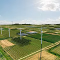 Sunny Picturesque Rural Landscape With Wind Turbines And Solar Panels Across Vast Lush Green Farmland