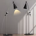 Modern Black Shade Floor Lamps With Curved Silver Poles And Wall Light Shadows