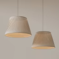 Two Modern Pleated Fabric Pendant Lights With Warm Glow On Gray Wall