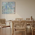 Modern Wooden Dining Table Set With Woven Chairs And Colorful Abstract Painting In Natural Light