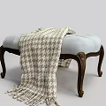 Upholstered Footstool With Soft Blue Cushion Wooden Carved Legs And Houndstooth Fringe Blanket
