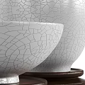White Ceramic Vessels with Crackle Texture in Different Shapes on Wooden Bases