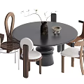 Modern Round Black Dining Table Set With Varied Designed Chairs Vase And Small Bowl Decor