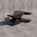 Modern Black Metal Clip With Ergonomic Grip On Textured Gray Surface