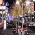 Vibrant Night Commercial Street With Street Lamps Neon Lights Outdoor Seating And Shop Signs