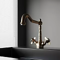 Classic Brass Kitchen Faucet With Double Handles On Black Countertop Near Window Blinds