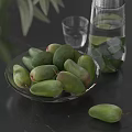 Fresh Green Mangoes In Glass Bowl With Water Glass And Lime Ice Cubes On Table