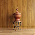 Red And Orange Carved Sculpture On Black Metal Stand With Wooden Wall Background