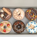 Assorted Donuts Decorated With Chocolate Fruits And Cookies In A Box