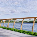 Brown Railing Along River With Green Grass Gray Pavement Trees Under Blue Sky White Clouds
