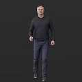 A Man Wearing Dark Sweater And Jeans Standing Against Dark Background