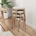 Stacked Stools With Beige Padded Seats And Wooden Legs On Light Wood Floor