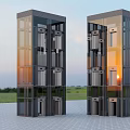 Modern Glass Facade Elevator Towers With Multiple Doors Against Evening Sky And Green Grass