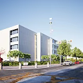Modern White Office Building With Large Glass Windows Surrounded by Green Trees Road and Cars