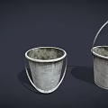 Three Different Sizes of Worn Metal Buckets with Handles on Dark Background