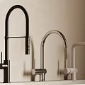 Three Modern Kitchen Faucets In Black Silver And White Finishes On Countertop