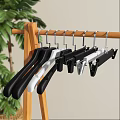 Black Hangers With Clips Hanging Coat Pants And Clothes On Wooden Rack