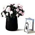 Dark Metallic Vase With Pink Roses And Green Leaves Alongside Silver Framed Butterfly