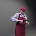 Man Wearing Red Cap In White Shirt And Red Apron Holding Black Bottle