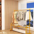 Yellow Metal Clothing Rack with Hanging Folded Clothes and Shoes in Indoor Setting with Window