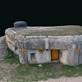 Old Concrete Bunker Structure With Grass Covered Roof Yellow Door And Round Markers