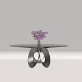 Round Black Tabletop Dining Table With Silver Unique Base And Purple Flower Vase