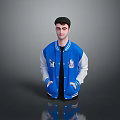 A Man In Blue Jacket With White Sleeves And Black T-Shirt Standing Against Gray Background