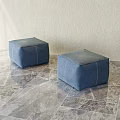 Two Blue Square Upholstered Ottomans On Marble Textured Floor With Light Wall 3d model