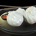 Delicious Steamed Buns on Black Plate with Red and White Sauces and Chopsticks