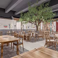 Chinese Style Restaurant Interior With Large Tree Center Wooden Tables Chairs Green Pillars Patterned Floor