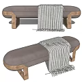 Gray Upholstered Ottoman With Gold Metal Legs And Striped Throw Blanket